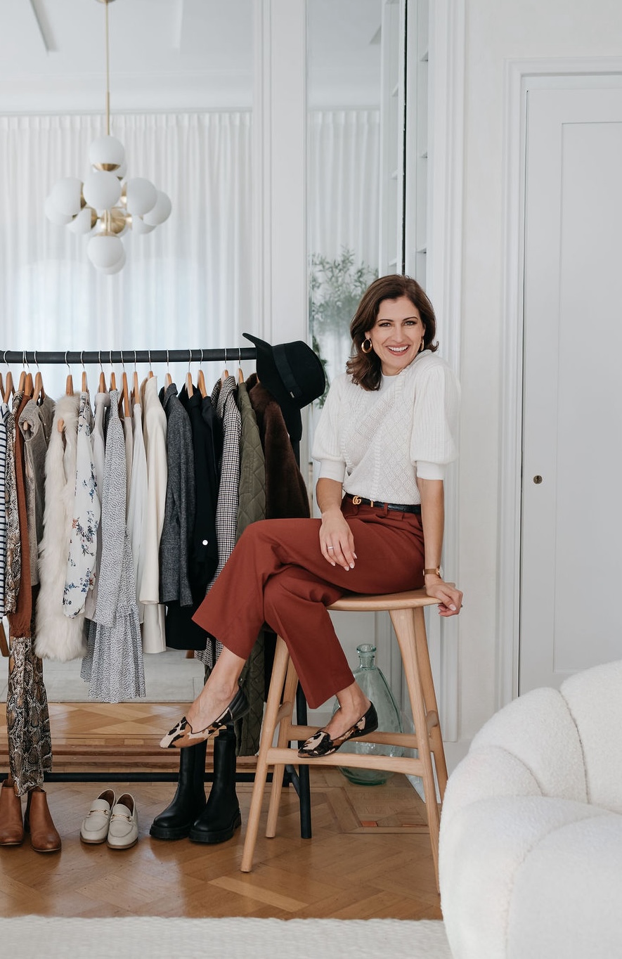Nerine Jones sat by a curated wardrobe rack